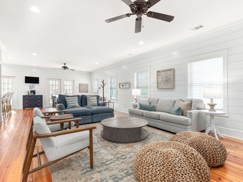 Spacious longcoastal living room with sectional sofa, armchairs, and coffee table.