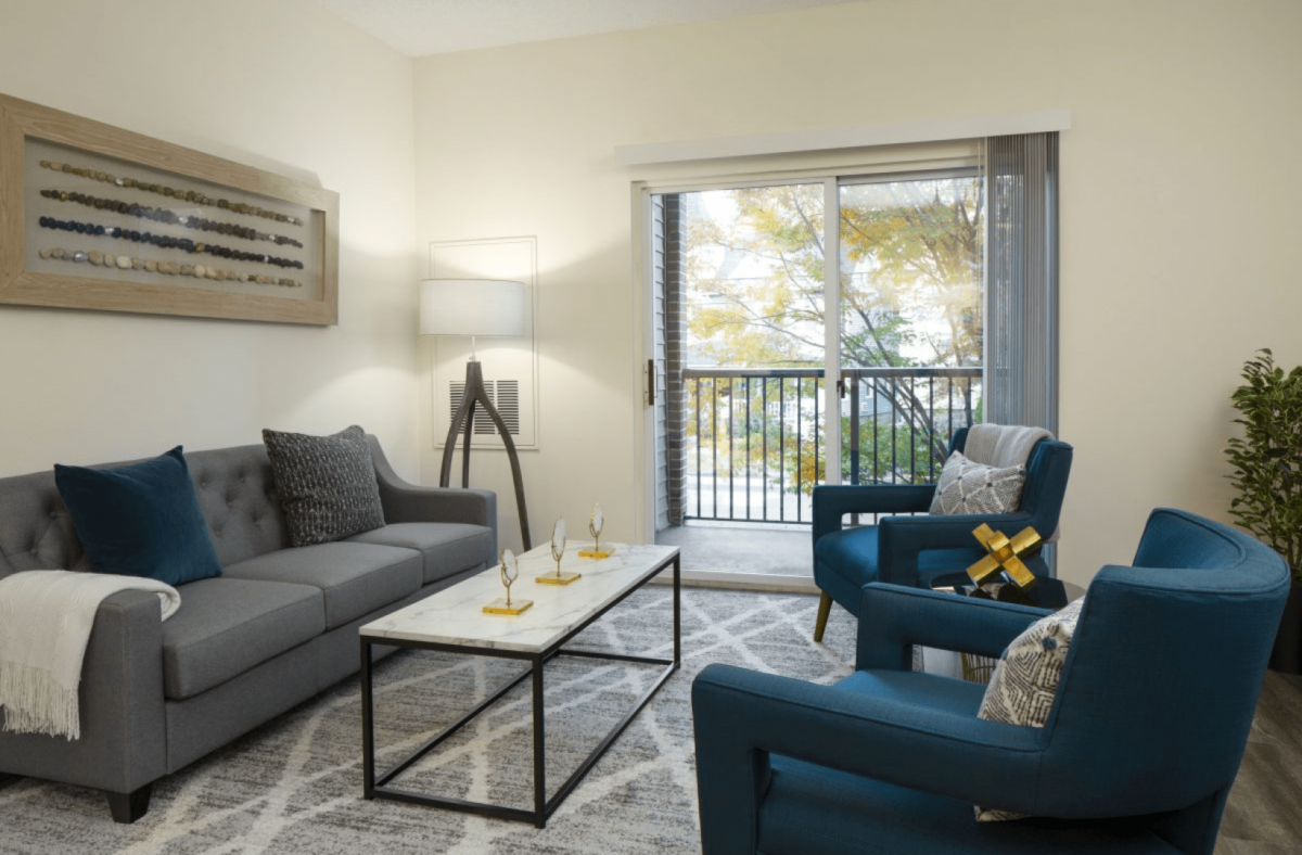 A glass-topped coffee table, white walls, and light fabric on the couch and curtains help the small space to feel larger