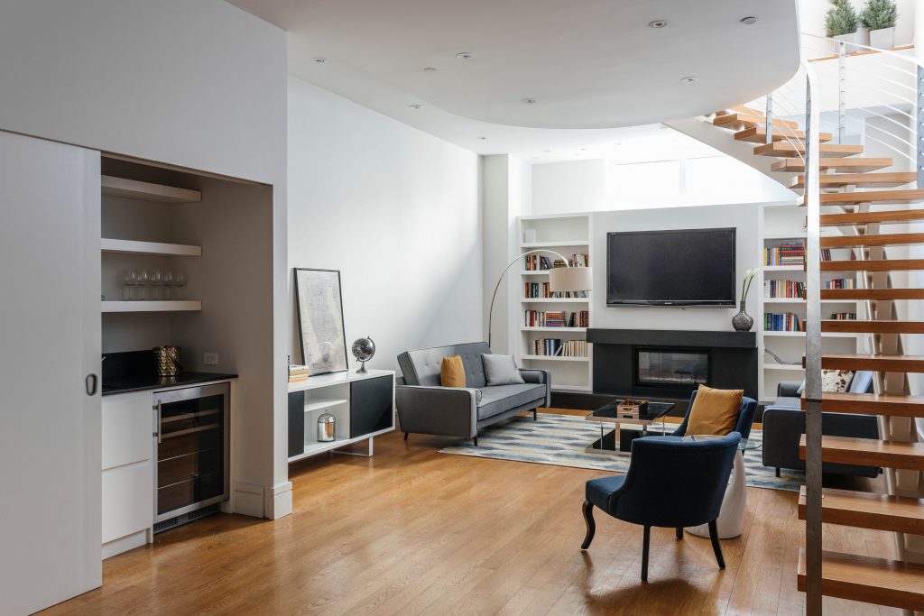 living room with art stand, sofa and chairs, bookshelf