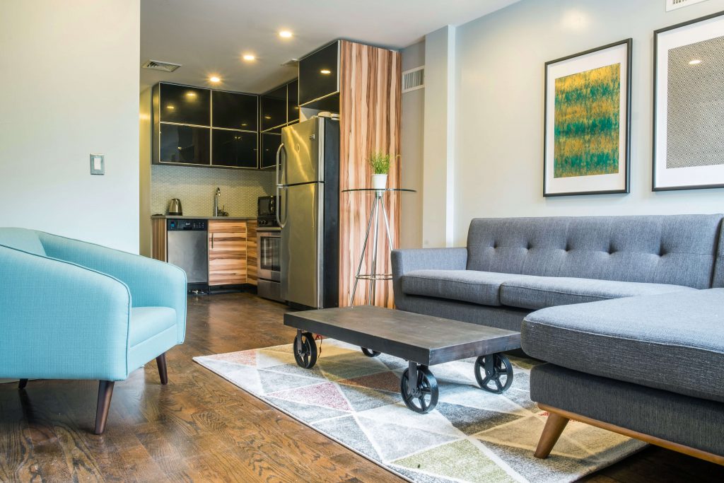 Living room with coffee table that has wheels, sofa, and sofa chairs