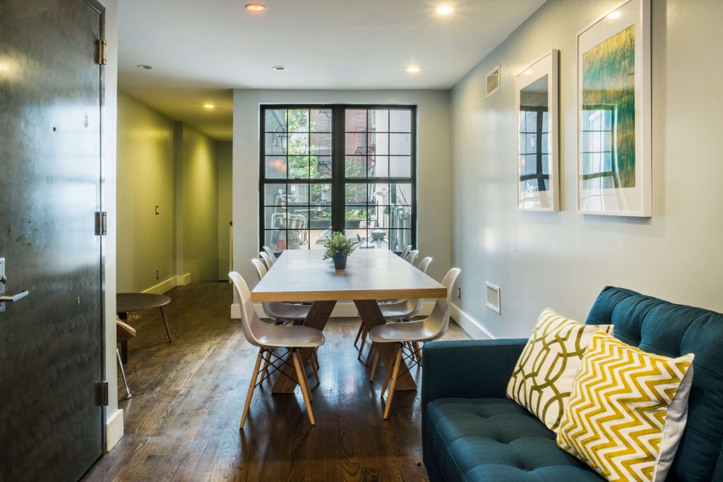 Dining area with a dining table and 8 dining chairs, sofa in the foreground