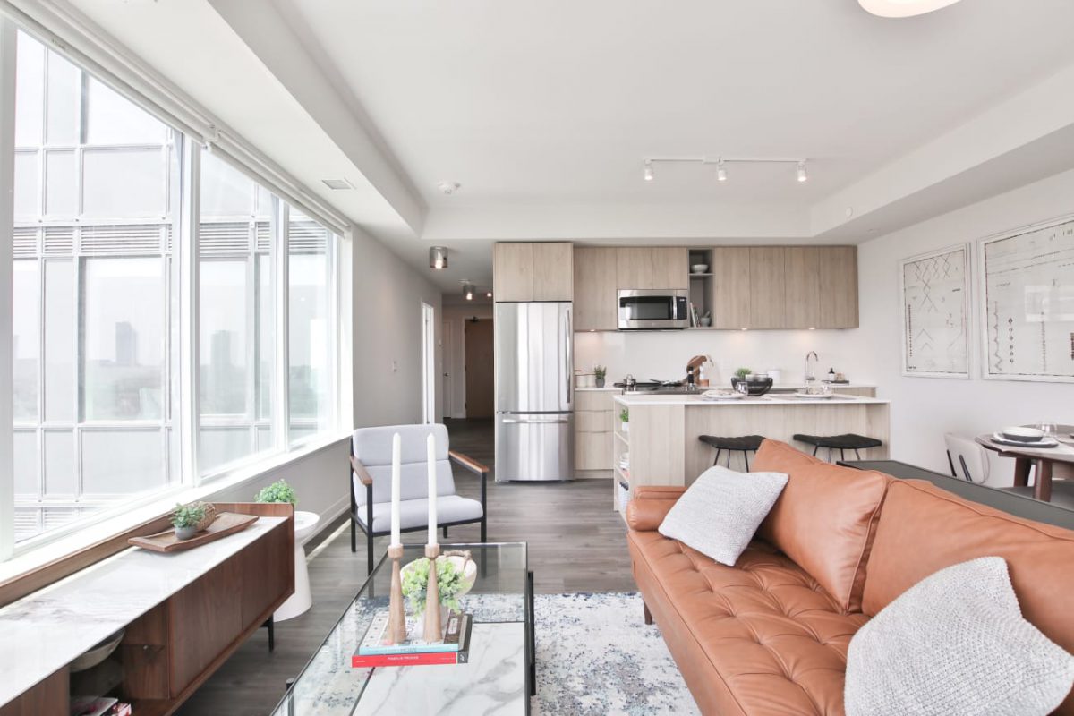 sofa facing balcony with kitchen in background