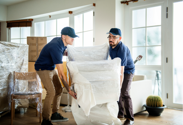 two movers moving a sofa into a new home