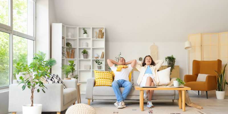 couple relaxing on their couch with a coffee table, accent chair and shelving in the background