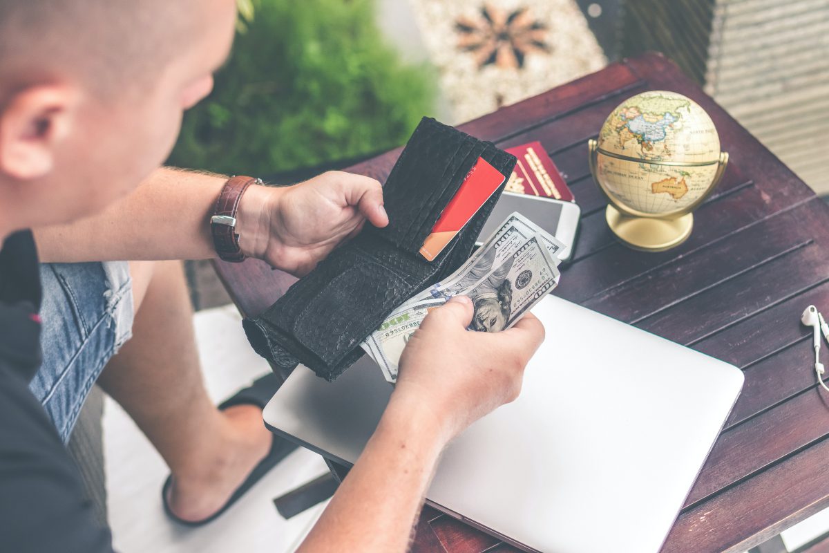  Un homme ouvre son portefeuille et sort de l'argent.